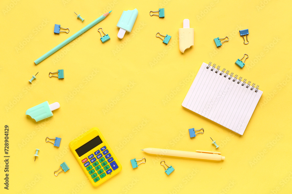 Frame made of notebook with different stationery supplies on yellow background Frame made of notebook with different stationery supplies on yellow background