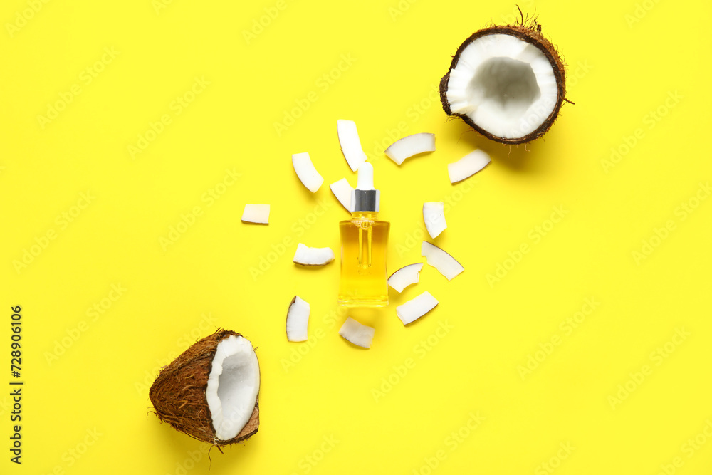 Bottle of coconut cosmetic oil on yellow background