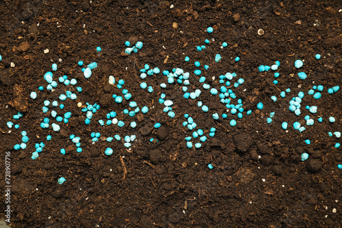 Brown soil with blue granular fertilizer photo