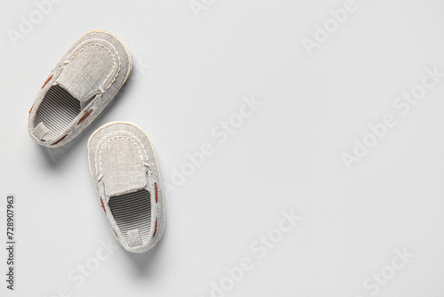 Stylish baby shoes on grey background