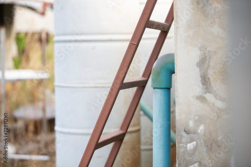 Close up of water pipes and ladder in the garden. Selective focus.