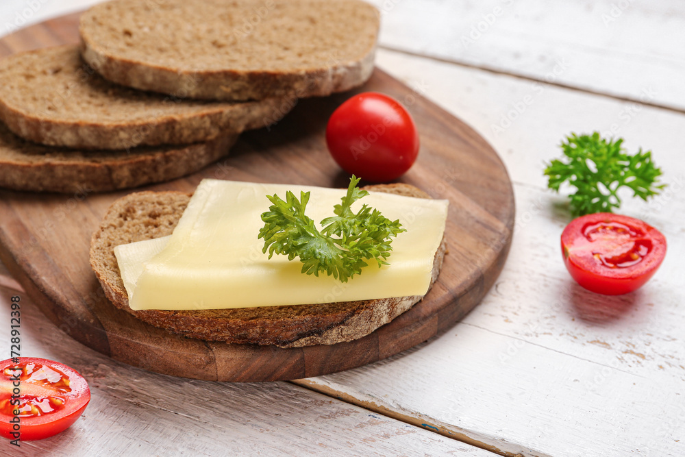 Tasty sandwich with cheese, tomatoes and parsley on light wooden background, closeup Tasty sandwich with cheese, tomatoes and parsley on light wooden background, closeup
