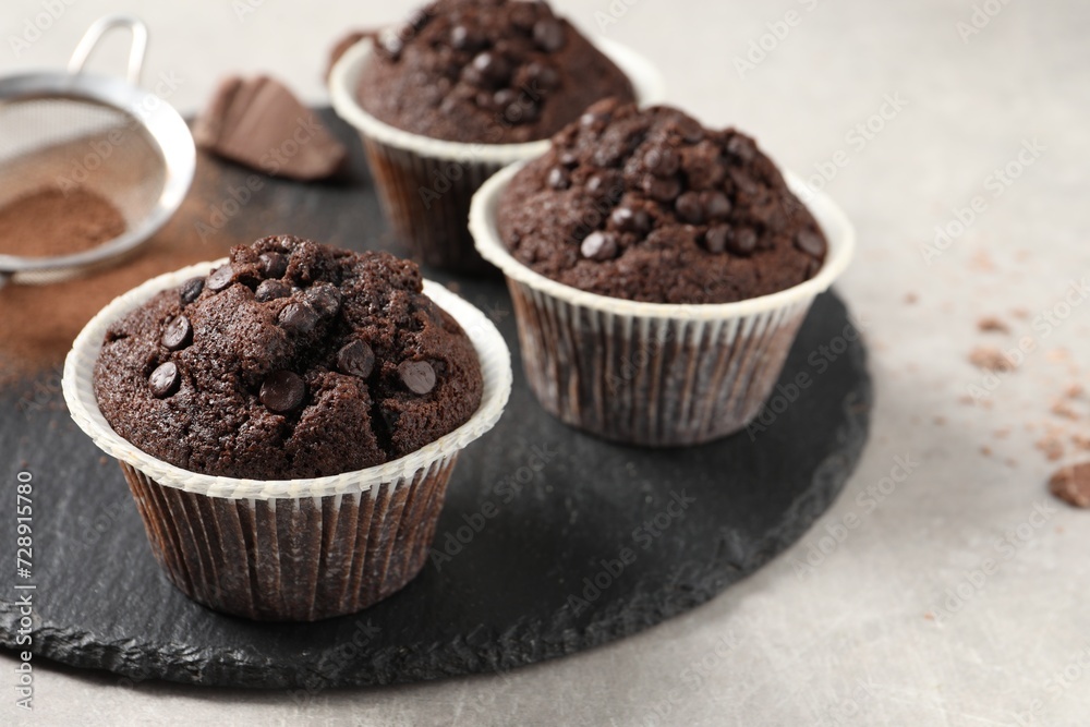 Delicious chocolate muffins on light table, closeup Delicious chocolate muffins on light table, closeup