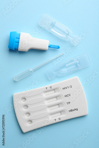 Disposable multi-infection express test kit on light blue background, flat lay