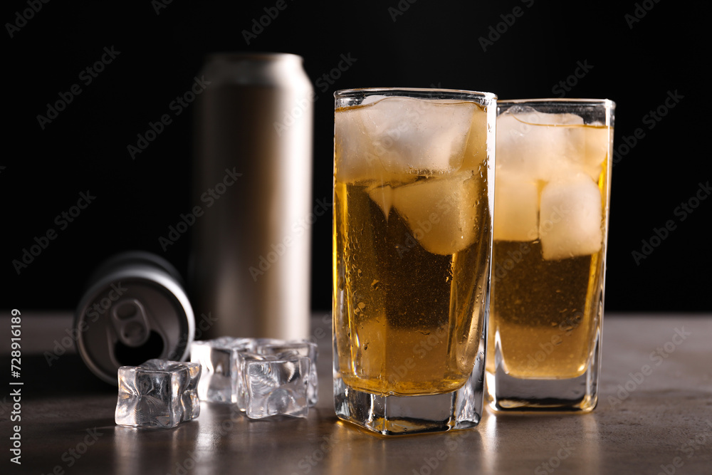 Energy drink in glasses, aluminium cans and ice cubes on grey table Energy drink in glasses, aluminium cans and ice cubes on grey table