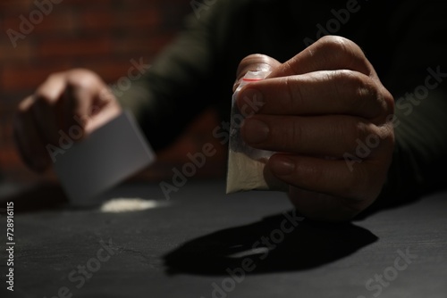 Addicted man with hard drug and blank card preparing for consumption at grey table, selective focus
