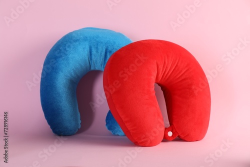 Light blue and red travel pillows on pink background