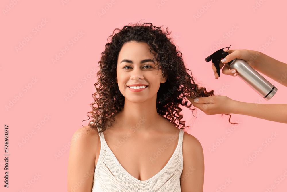 Ταπετσαρία Beautiful African-American woman and hand with hair spray on pink background