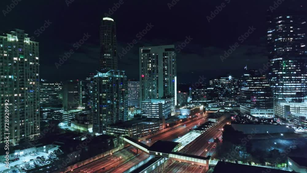 Stunning lighting Skyline of Atlanta City at night. Travelling vehicles on underpass highway. Aerial orbiting shot. Georgia,USA Stunning lighting Skyline of Atlanta City at night. Travelling vehicles on underpass highway. Aerial orbiting shot. Georgia,USA