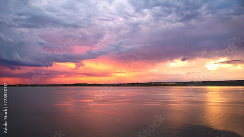  We see an incredible sunset, in the middle of the calm of the lake, the horizon seems to catch fire, a storm in formation accompanies, the beauty of the evening. El Carrisal Mza Dam. Arg. © GUSTAVO