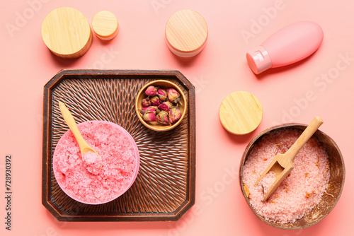 Composition with cosmetic products and dried rose flowers on pink background
