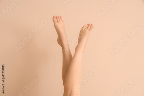 Barefoot woman on beige background