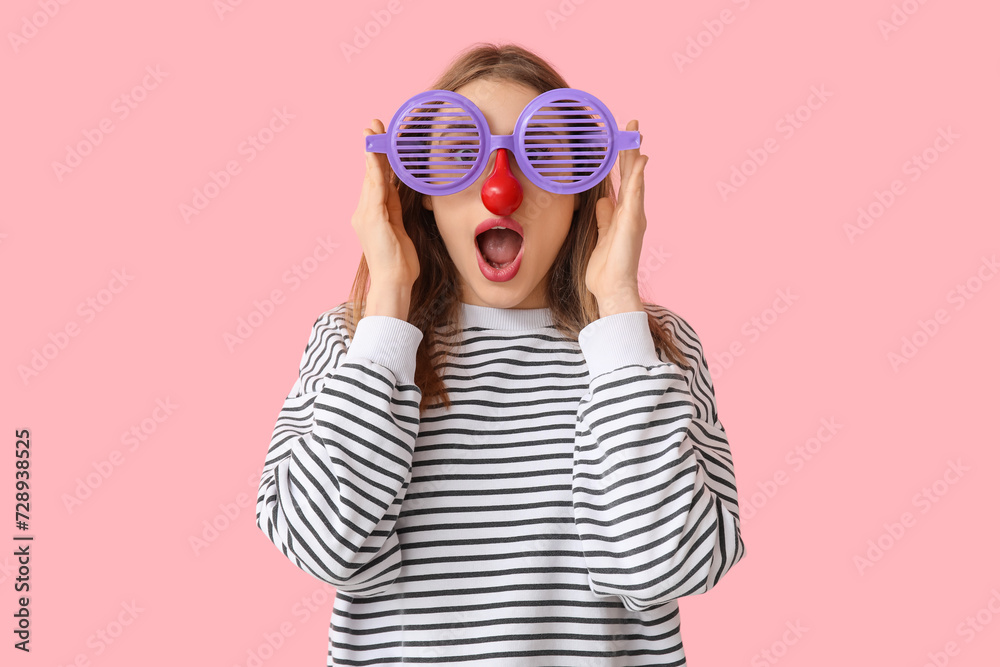 Beautiful young shocked woman in funny disguise on pink background. April Fools Day celebration - obrazy, fototapety, plakaty 