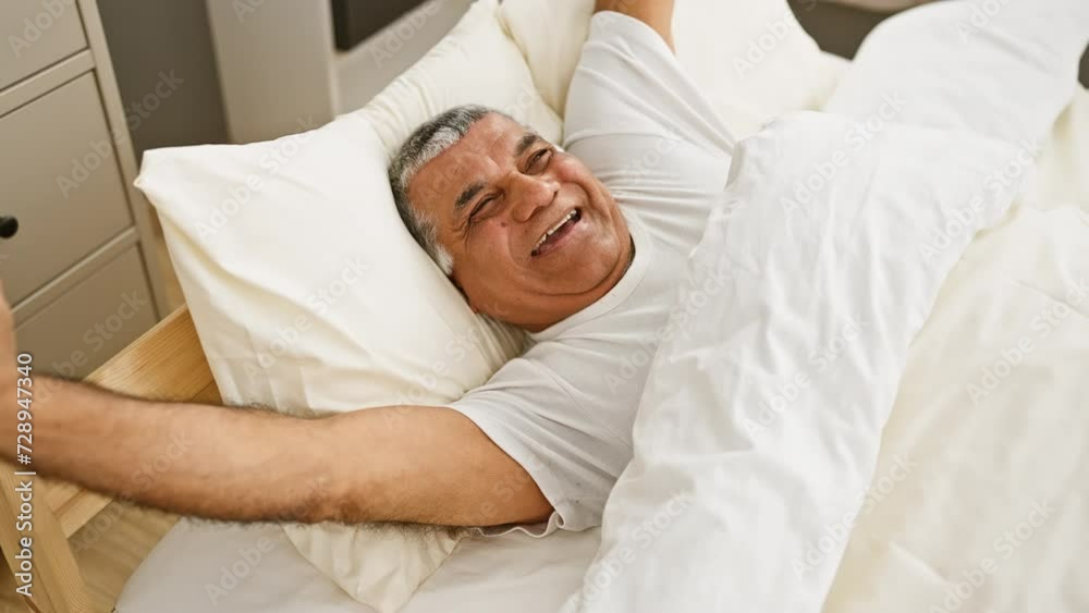 Smiling senior man relaxing in a cozy bedroom, conveying a sense of happiness and comfort. Smiling senior man relaxing in a cozy bedroom, conveying a sense of happiness and comfort.