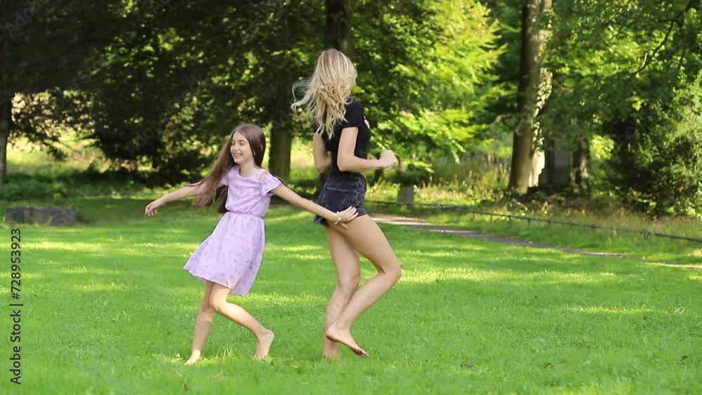 Mother and daughter dancing and having fun in a park Mother and daughter dancing and having fun in a park