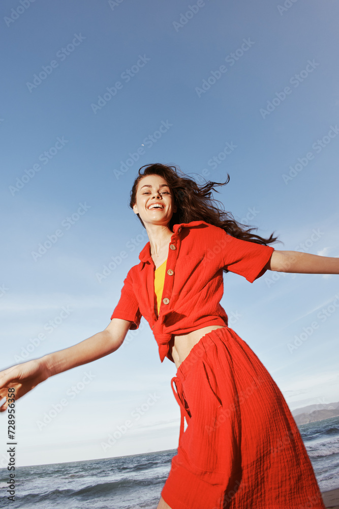 Joyful Woman Dancing in the Summer Breeze on the Beach, Smiling with Freedom and Happiness Joyful Woman Dancing in the Summer Breeze on the Beach, Smiling with Freedom and Happiness
