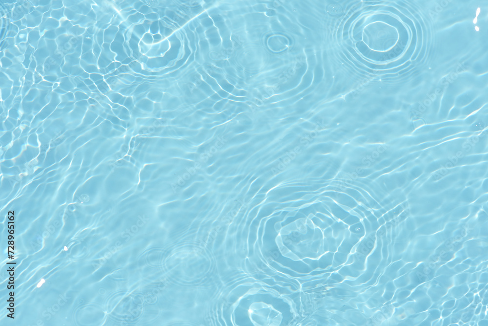 Water surface. Bluewater waves on the surface ripples blurred. Defocus blurred transparent blue colored clear calm water surface texture with splash and bubbles. Water waves with shining pattern. Water surface. Bluewater waves on the surface ripples blurred. Defocus blurred transparent blue colored clear calm water surface texture with splash and bubbles. Water waves with shining pattern.