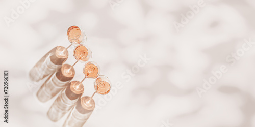 Fototapeta Naklejka Na Ścianę i Meble -  Rose wine glasses Minimal flat lay. Holiday aesthetic still life, top view wineglass at sunlight, plant leaves sun shadow, monochrome beige pink pastel color, drink background, copyspace, banner