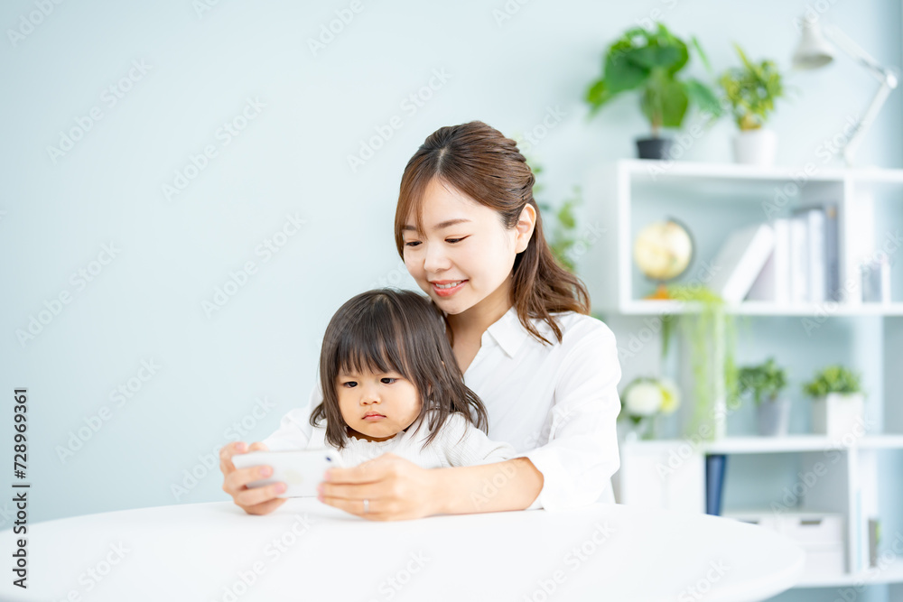 子供と一緒に携帯を見るお母さん 子供と一緒に携帯を見るお母さん