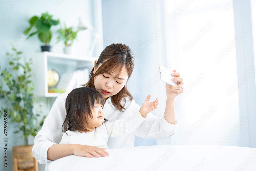 子供から携帯を取り上げる女性 子供から携帯を取り上げる女性
