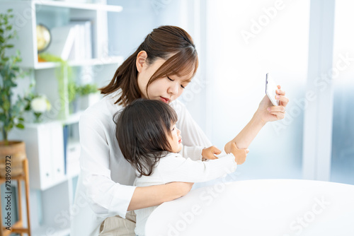 子供から携帯を取り上げる女性 photo