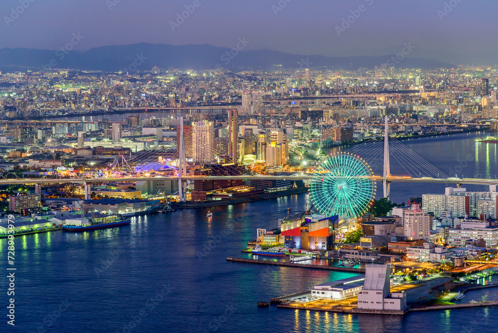Osaka city skyline aerial twilight view of Osaka bay area with the ferris wheel. Japan architecture landscape background.