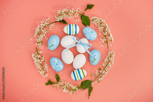Easter eggs and cherry branches in the shape of a circle on a pink background. Copy space. Easter background, top view