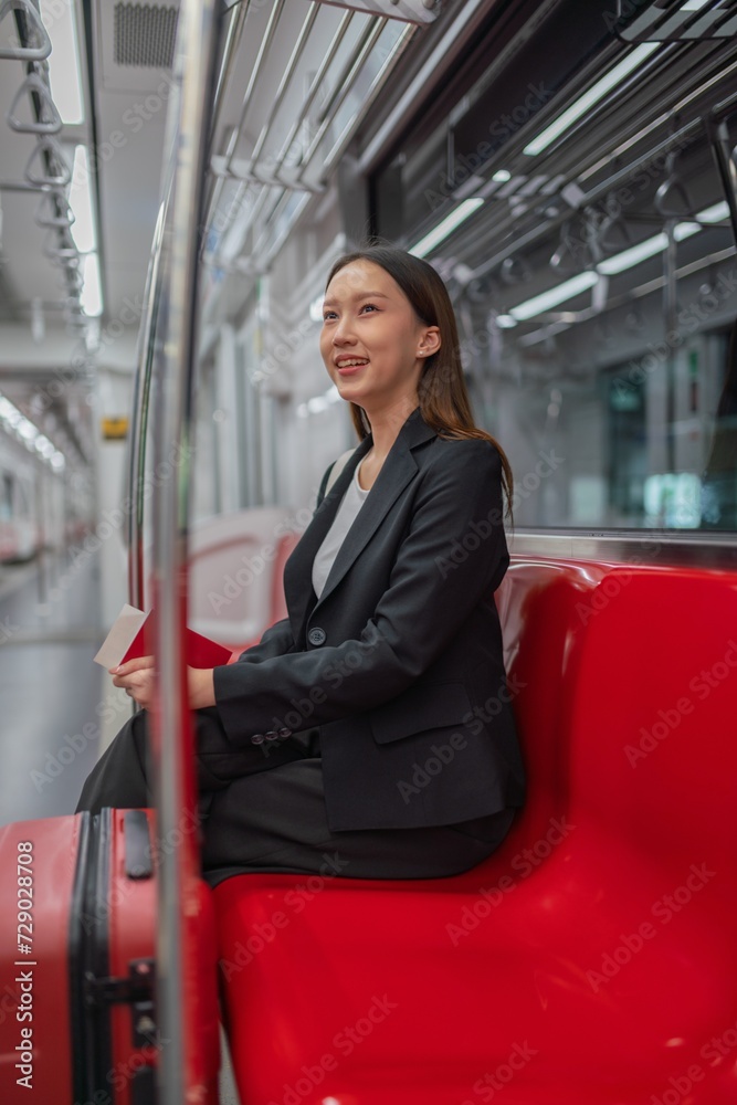 Asian businesswoman with luggage in a skytrain to the airport