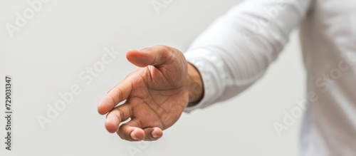 Attractive professional extending hand on white backdrop.