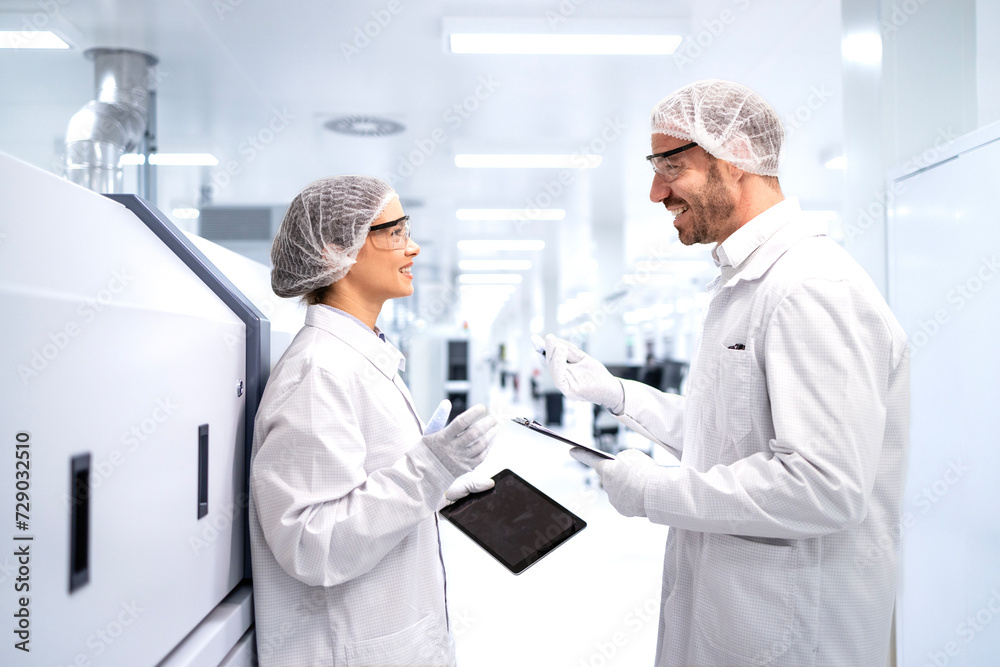 Factory workers consulting each others and sharing ideas in electronics production factory. Factory workers consulting each others and sharing ideas in electronics production factory.