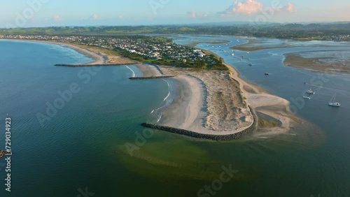 Aerial: Beach and sandspit in the holiday town of Omaha, near Warkworth, New Zealand photo