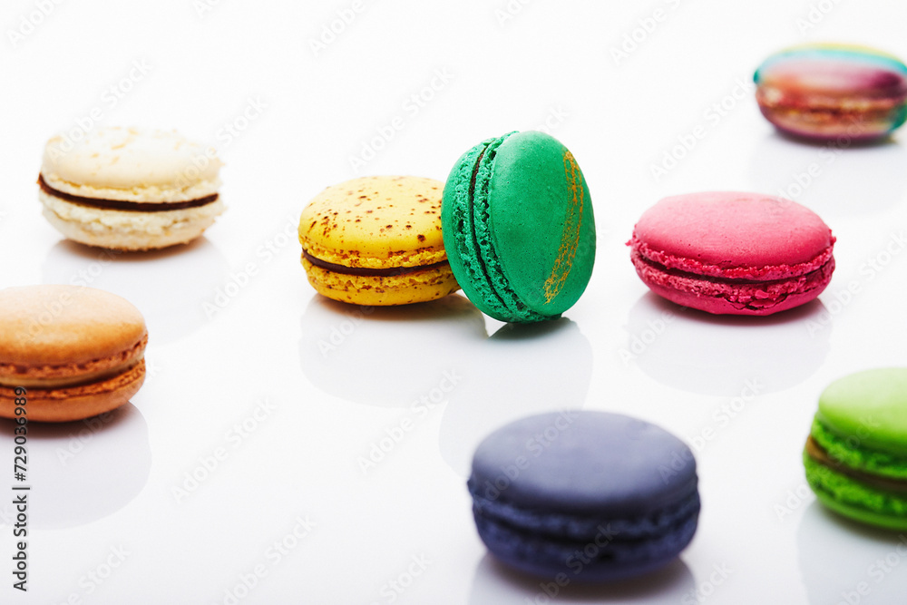 Multicolored stacked and separated macarons displayed on white background with reflection Multicolored stacked and separated macarons displayed on white background with reflection
