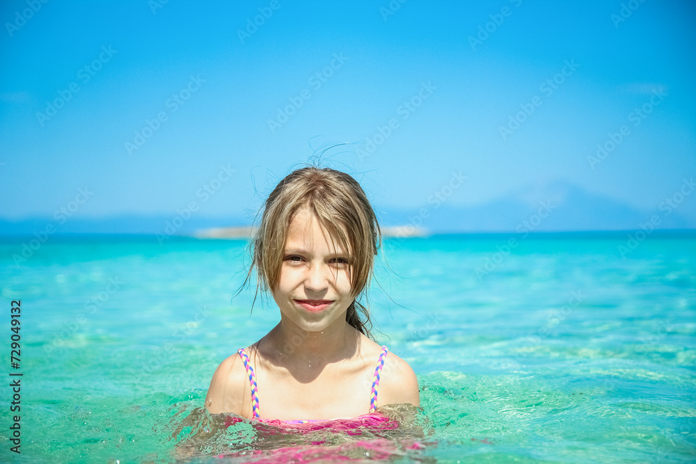 happy child in a vest at the sea playing