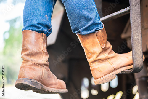 Fotografie Action of a man wearing leather safety shoe is climbing up on the train locomotive driver cabin ladder