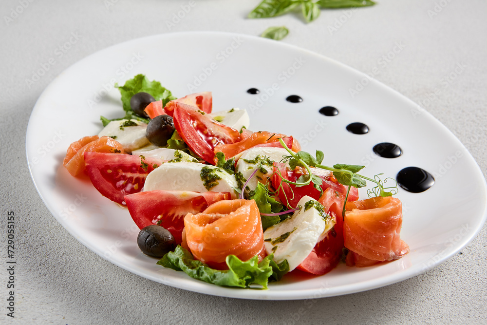 Salmon and mozzarella Caprese salad with fresh tomatoes, top view. Ideal for culinary magazines and healthy eating blogs