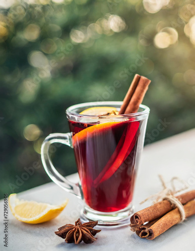 Mulled red wine with cinnamon, orange and spices with bokeh background