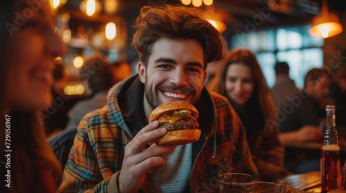 Cheerful young man with friends eating a delicious burger in a casual dining bar.