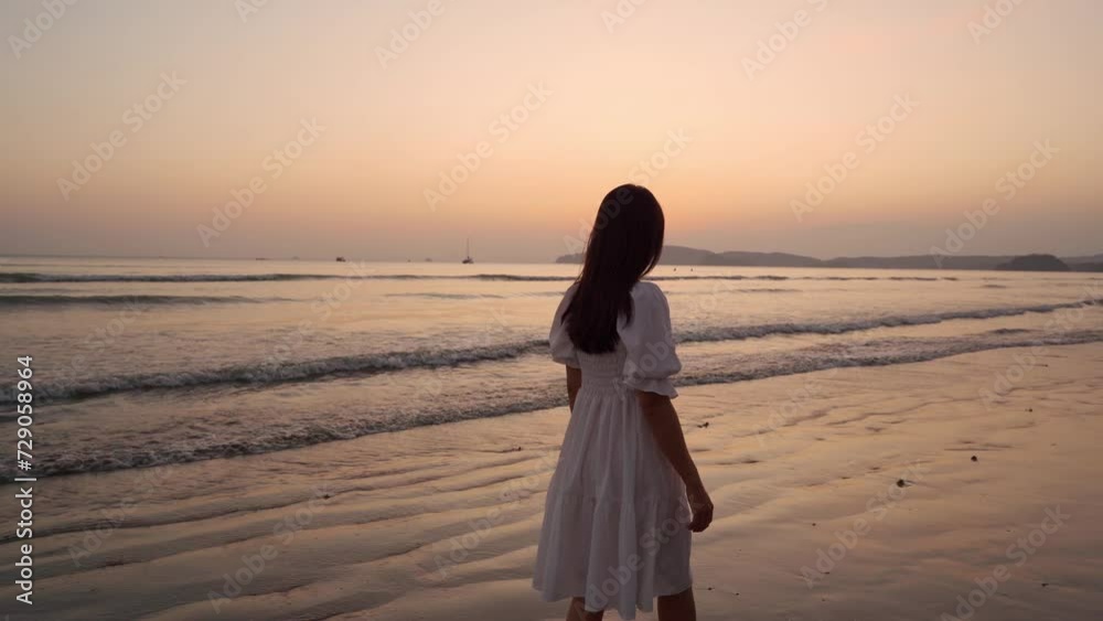 Young woman traveler relaxing and enjoying the beautiful sunset on the tranquil beach, Travel on the summer vacation concept Young woman traveler relaxing and enjoying the beautiful sunset on the tranquil beach, Travel on the summer vacation concept