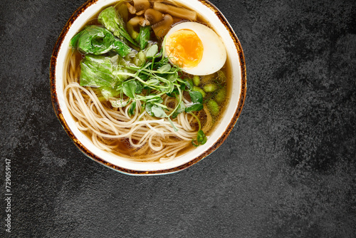 Aromatic ramen with a soft-boiled egg, leafy greens, and mushrooms, served in a rustic blue bowl