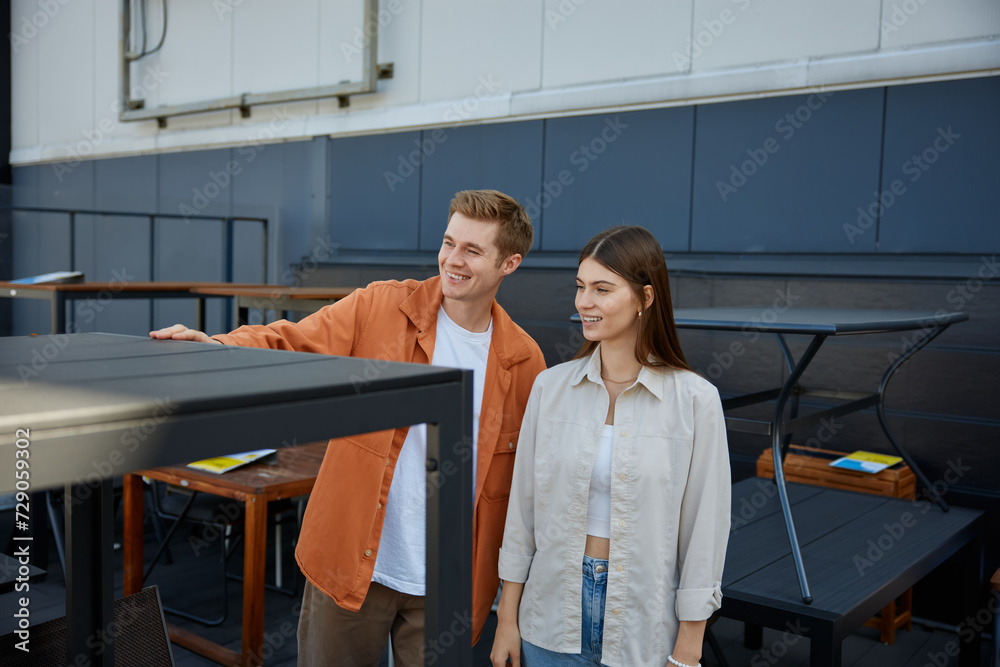 Happy loving young family couple choosing table for home at shopping mall Happy loving young family couple choosing table for home at shopping mall