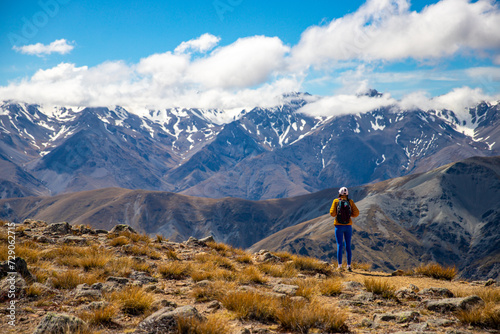 backpacker enjoying the stunning panorama of new zealand alps from the top of mount somers in canterbury