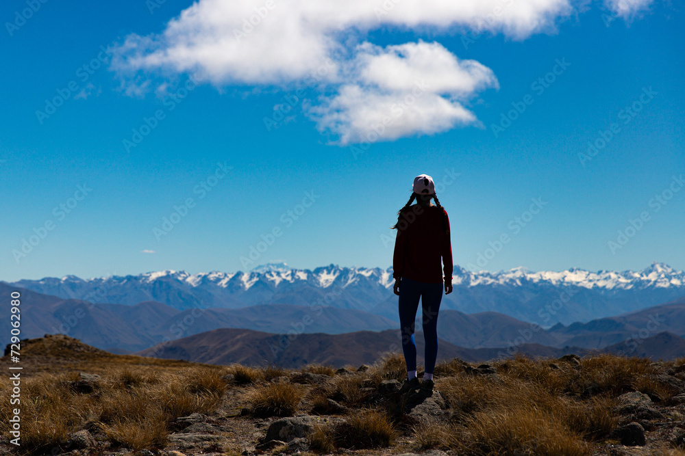 backpacker enjoying the stunning panorama of new zealand alps from the top of mount somers in canterbury