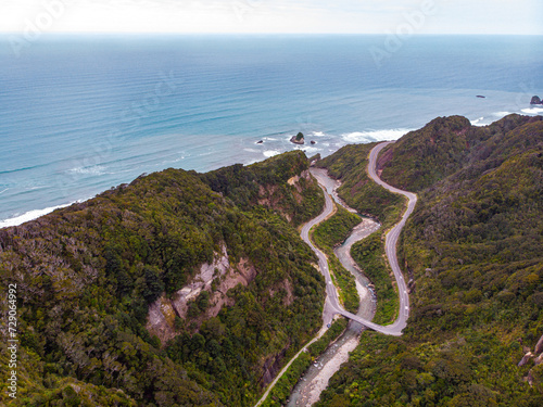 aerial panorama of the west coast of new zealand south island; winding road next to turquois water, mighty cliffs and little islands, ten mile creek near greymouth and paparoa national park	 photo