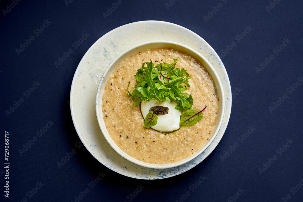Oat porridge with truffle paste and poached egg. Breakfast oatmeal