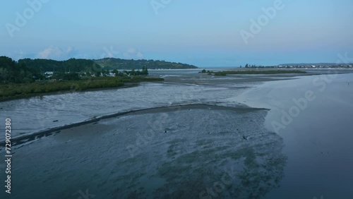 Aerial: Whangateau Harbour in low tide in sunset. Point Wells, near Warkworth, New Zealand photo