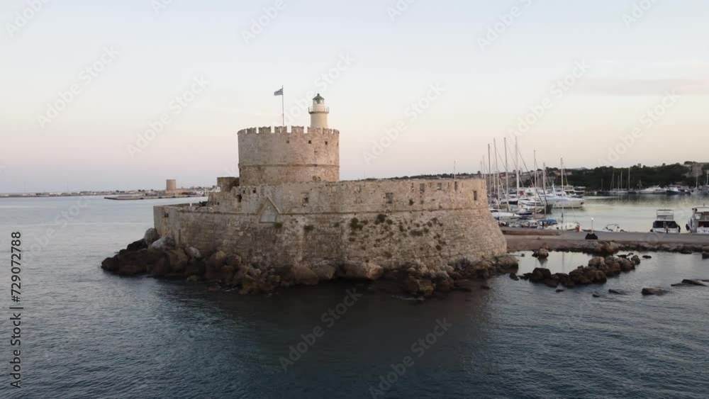 Old Lighthouse and Greek Flag Flyover in Rhodes, Greece Old Lighthouse and Greek Flag Flyover in Rhodes, Greece