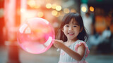 Happy little asian girl holding pink balloon in  left hand