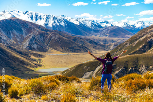 beautiful hiker girl enjoying the view from the top of trig m mountain in Torlesse Tussocklands Park, canterbury, new zealand south island