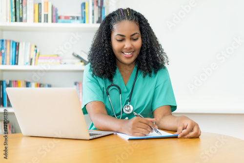 Laughing latin american medical student or female nurse working at office