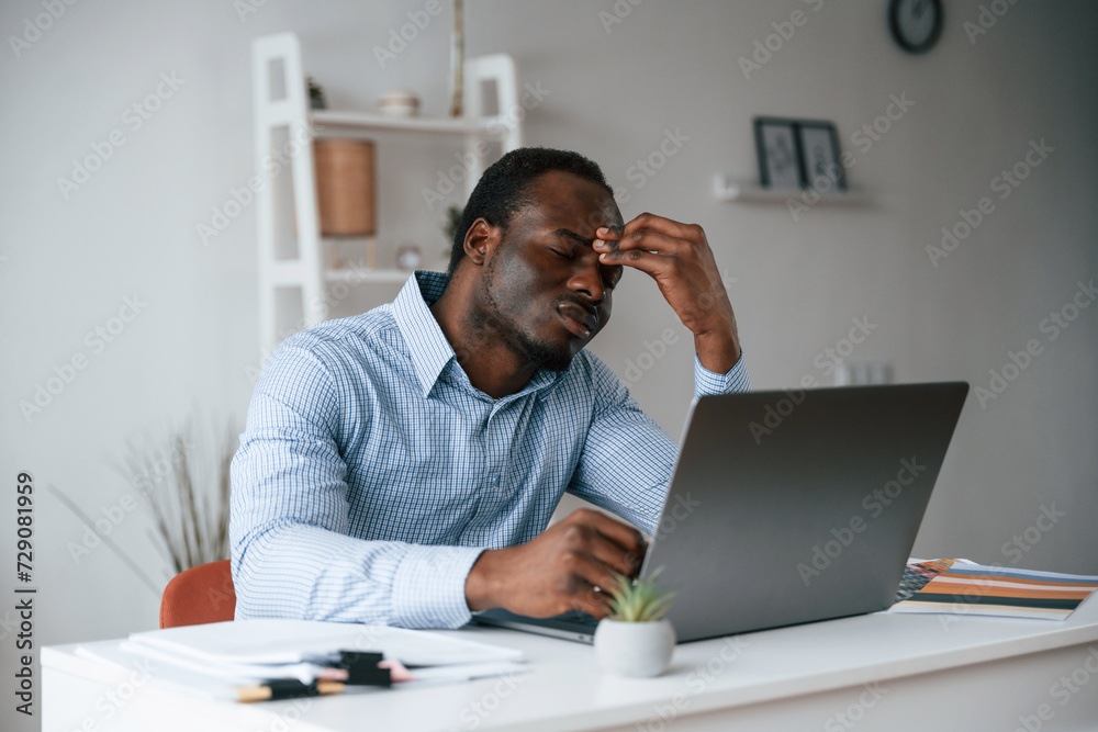 Feeling bad, stressful. Businessman is working in the office by laptop Feeling bad, stressful. Businessman is working in the office by laptop